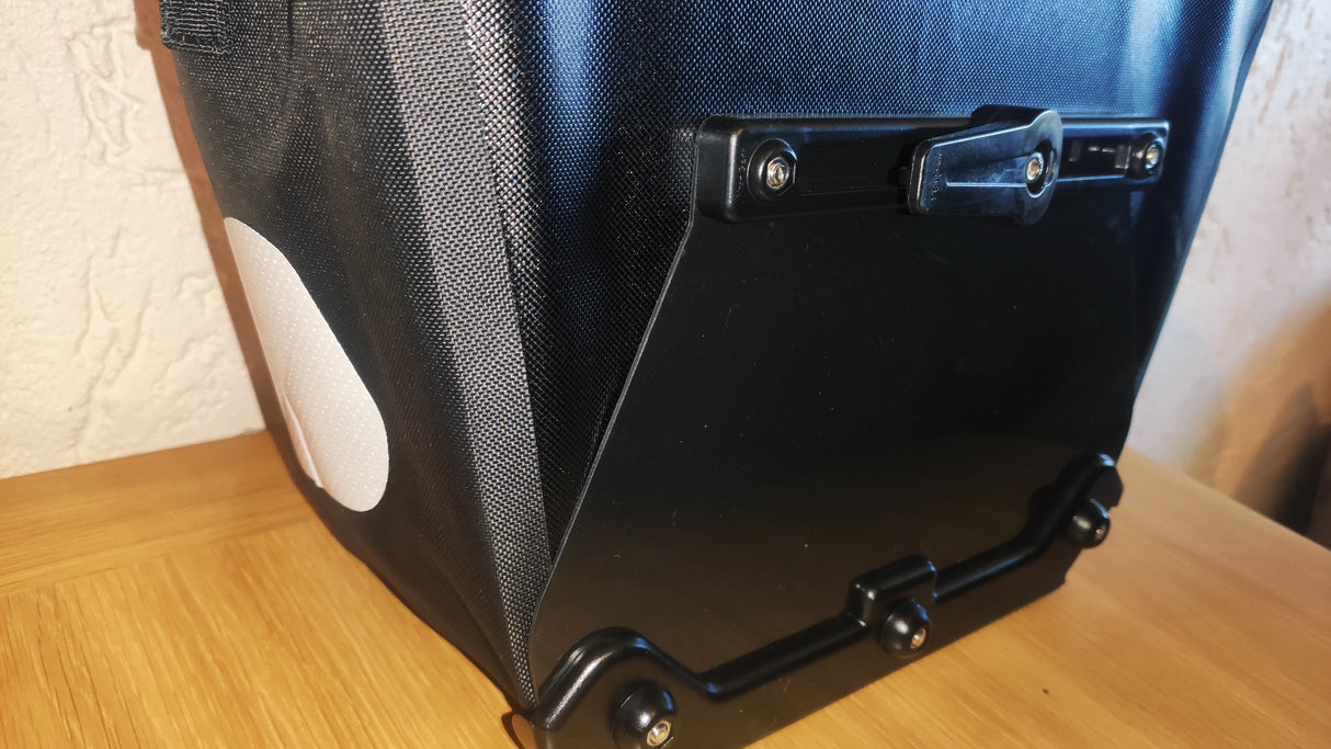 Elife vanntett sykkelveske til elsykkel på et bord med fokus på hanken på railsystemet som holder vesken på plass på sykkelen