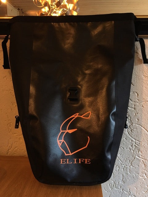 Elife vanntett sykkelveske til elsykkel på et bord sett fra fronten med gjenskinn av lyset i vesken