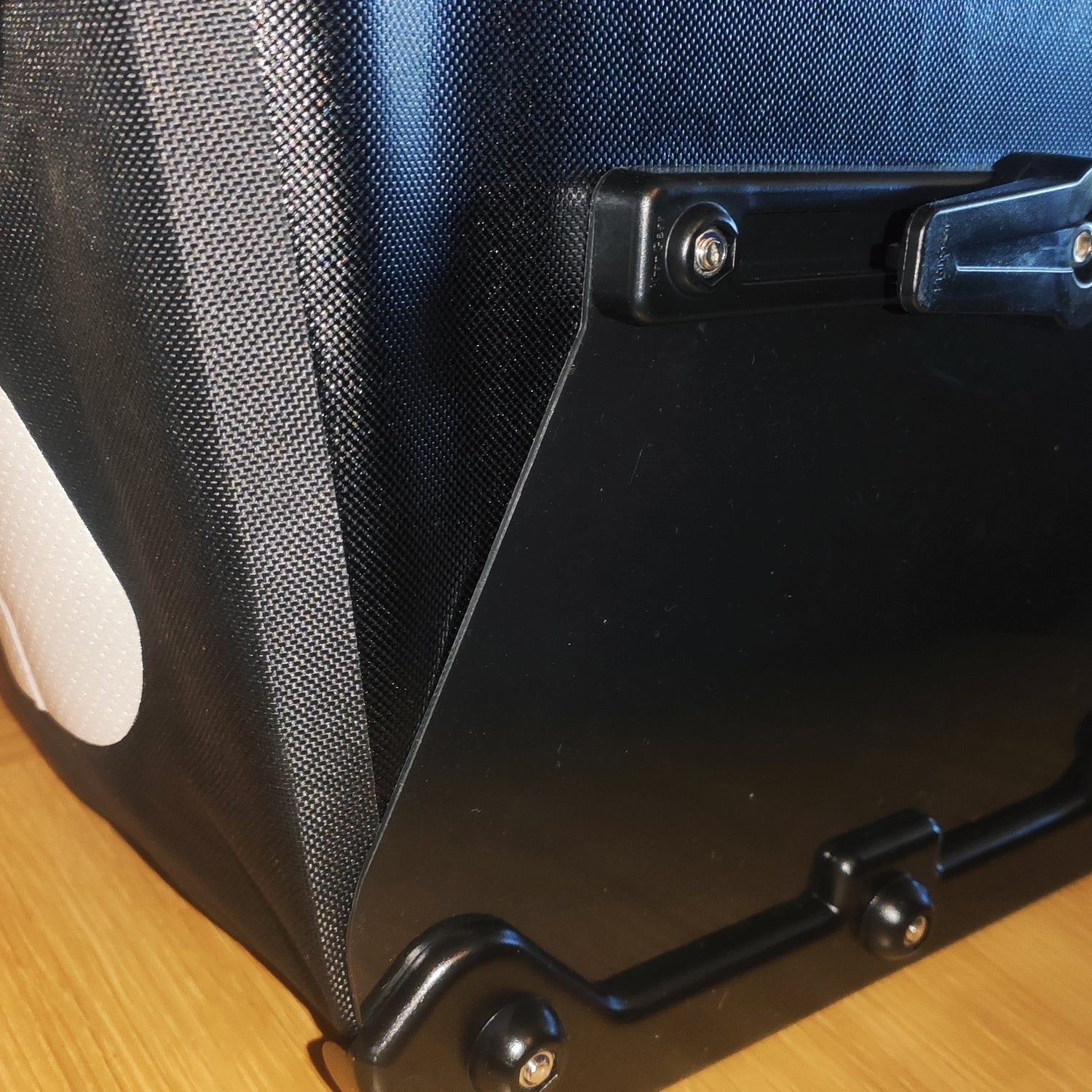 Elife vanntett sykkelveske til elsykkel på et bord med fokus på hanken på railsystemet som holder vesken på plass på sykkelen