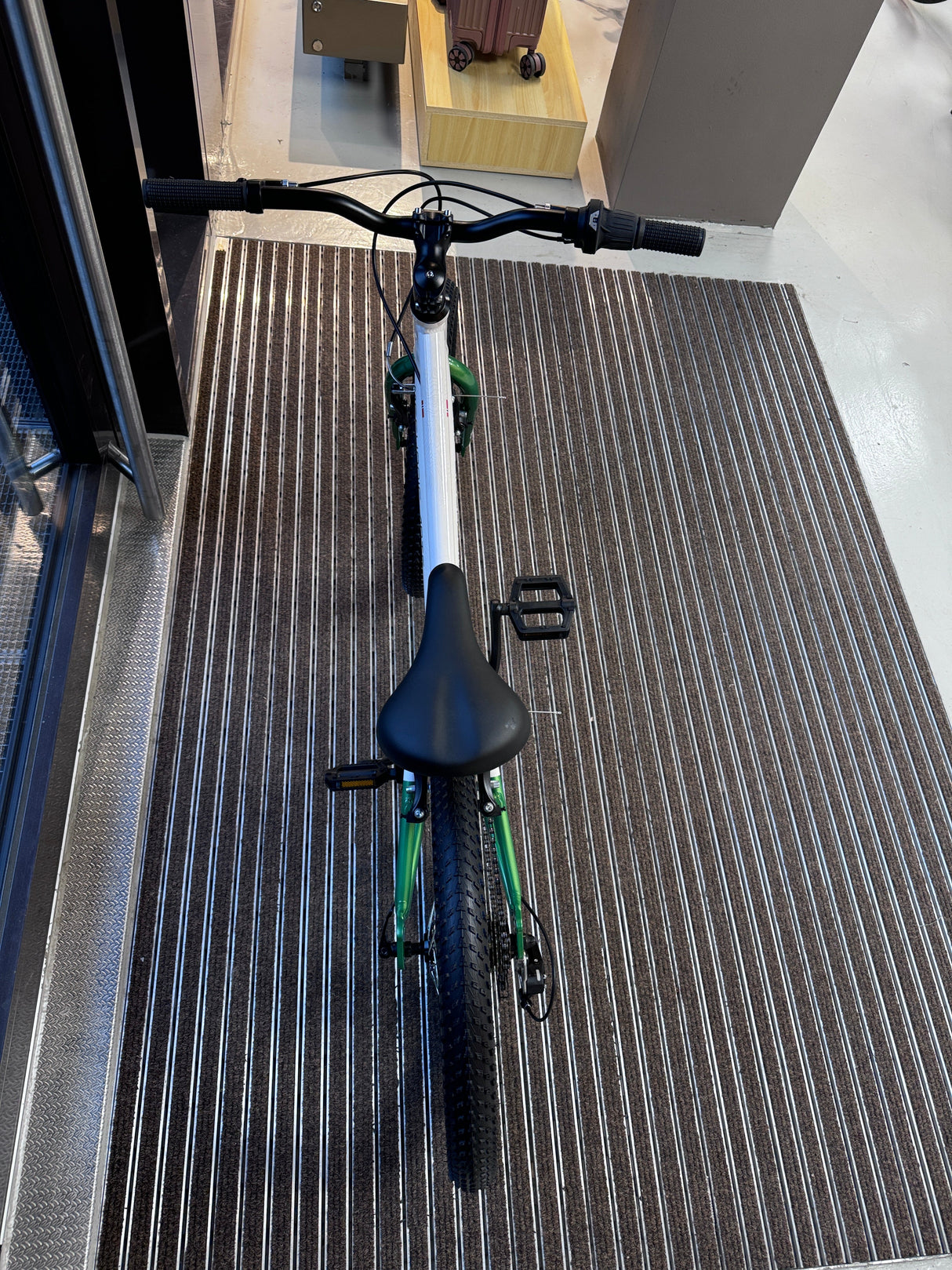 Nærbilde av styre og grep på Mechanic Arts Raskr barnesykkel – teksturerte håndtak og Shimano girskifter med +/– indikator for enkel giring