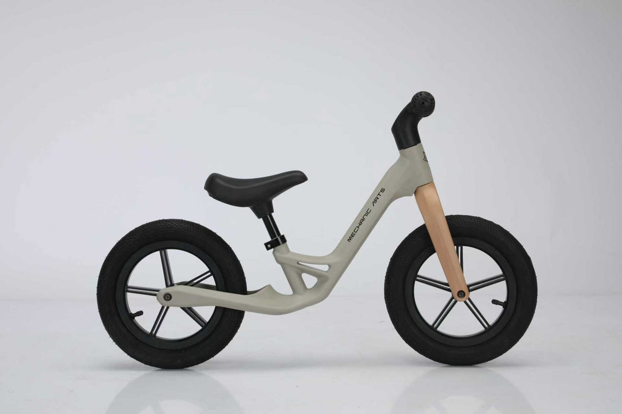 Beige Mechanic Arts Trillr balanse sykkel på hvit bakgrunn, studiofoto fra siden – enkel og elegant barnesykkel uten pedaler